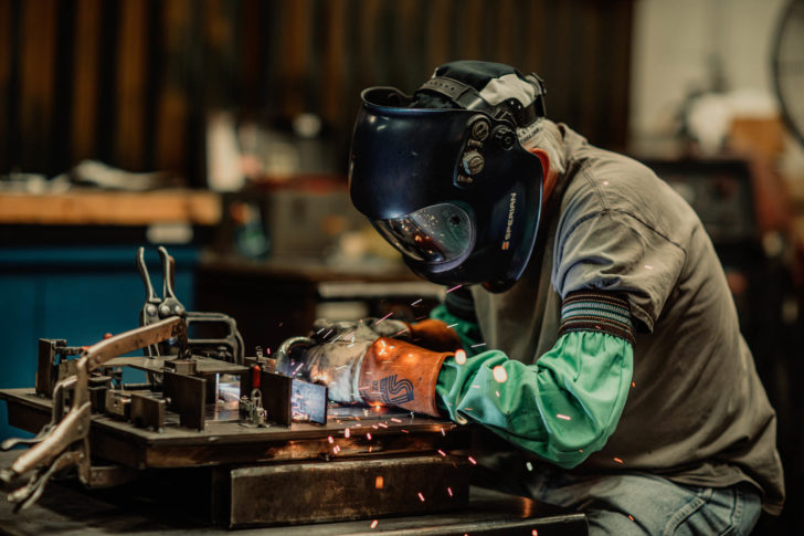 Dawson worker in protective gear grinding metal