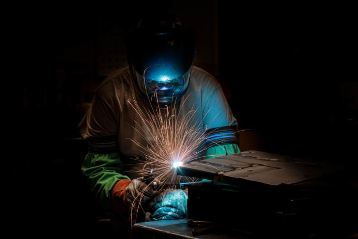 Dawson worker in protective gear welding metal